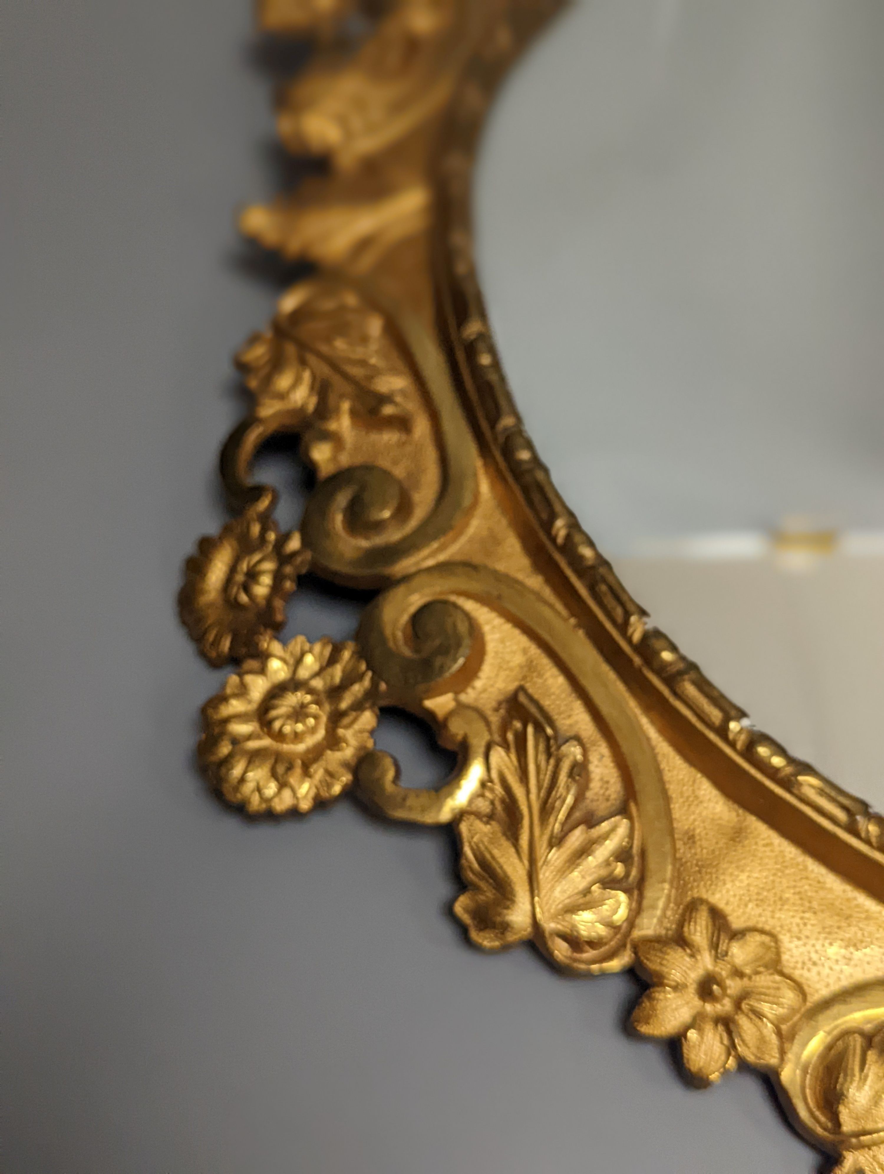 A pair of gilt brass wall mirrors, decorated with bats and flowers 56cm